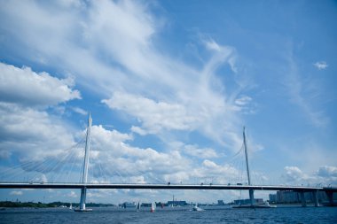 Mavi gökyüzüne karşı nehrin üzerindeki gri yol köprüsü