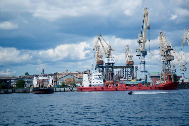 Gemileri boşaltmak için sanayi vinçleri limanda