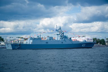 Şehrin mavi gökyüzüne karşı bir rıhtımda gri renkli savaş gemisi