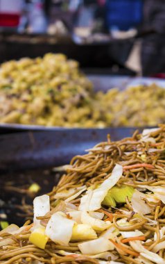 Bir kızartma tavası wok sokak gıda pazarında Asya Çin Eriştesi