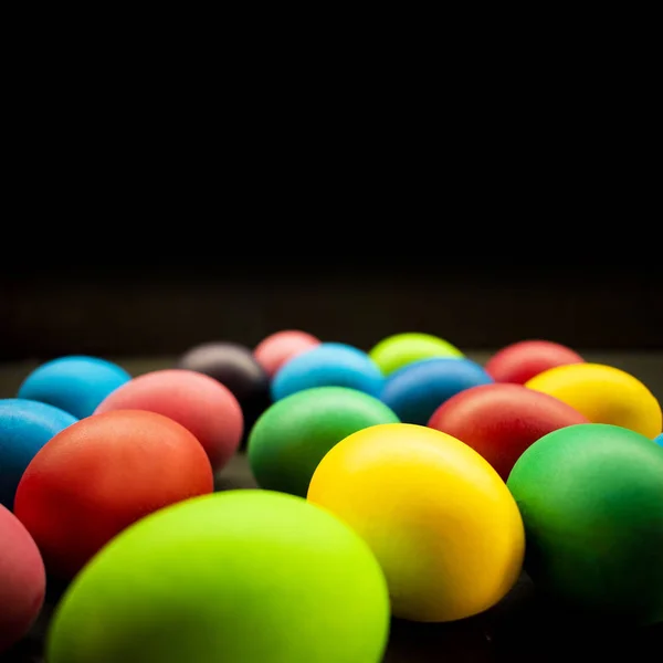Variété d'œufs de Pâques peints sur fond noir — Photo