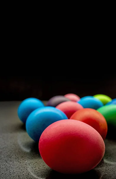 Разнообразие окрашенных пасхальных яиц на черном фоне — стоковое фото