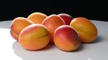 Siyah beyaz arka planda olgun taze kayısılarla omuz omuza.