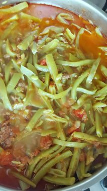 Kaynayan suda siyah bir tencerede yeşil fasulye pişir, yavaş çekim, yakın çekim, üst manzara. Sağlıklı beslenme