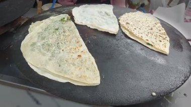 Geleneksel Türk sokak yemekleri olan 'gozleme' düz ekmekleri pişirmek.