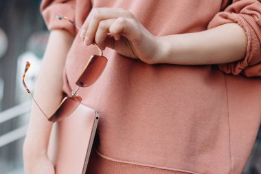 Dışarıda dizüstü bilgisayar ve pembe sunglasess tutan kadın. Sosyal medya kavramı. Freelancer. Blogger