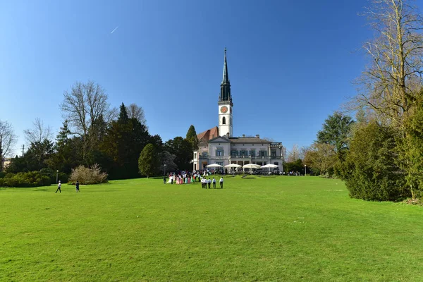 Lidé v parku Villette před kostelem svatého Jakuba. Město Cham, Kanton Zug, Švýcarsko, Evropa. — Stock fotografie