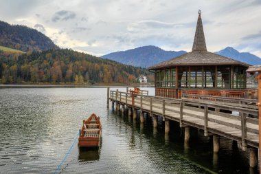 Bir bulutlu sonbahar günü Grundlsee gölde demirli bir ahşap teknede. Alpler manzarası. Grundlsee, Salzkammergut, Styria, Avusturya Liezen İlçe Belediyesi.