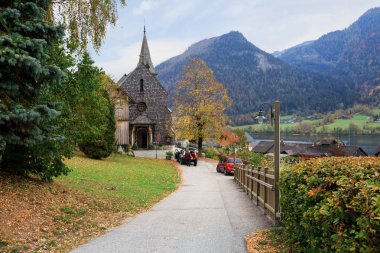 Kasaba Grundlsee bir bulutlu sonbahar gününde eski parish Kilisesi ile. Alpler manzarası. Salzkammergut, Styria, Avusturya Federal devlet bölgesinin.