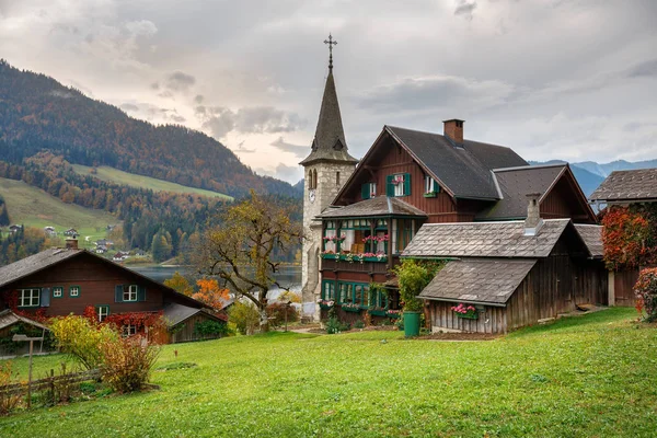 Casas residenciales tradicionales de madera en la orilla del lago Grundlsee en un día nublado de otoño. Ciudad de Grundlsee, Estiria, Austria . —  Fotos de Stock