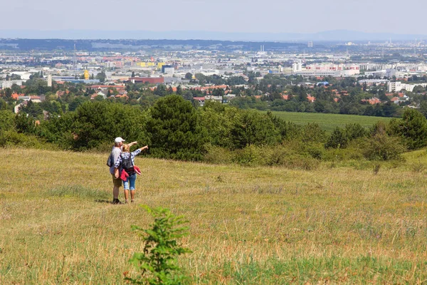 Couple of hikers standing on the Perchtoldsdorf heath and looking at the city of Vienna, Austria. — Stock Photo, Image