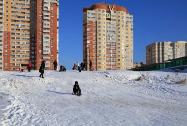 Yeni konut mahalle önünde tepeden aşağı kızakla insanlar. Balashikha, Moscow region, Rusya Federasyonu.