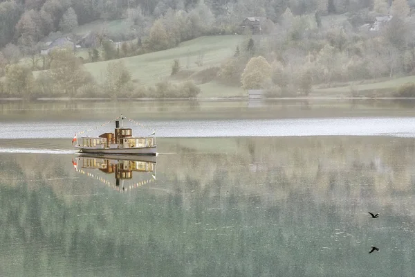 Bateau de plaisance tôt le matin brumeux sur le lac Grundlsee. Ville de Grundlsee, Autriche . — Photo