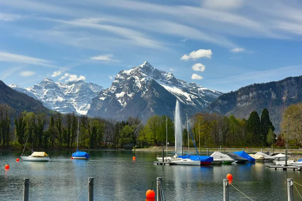 Bateaux amarrés sur le lac de Walensee. Alpes enneigées. Village de Weesen, Suisse . — Photo