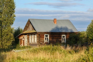 Çimenlerle büyümüş bir avluya sahip eski kütük ev. Visim Köyü, Sverdlovsk region, Rusya Federasyonu.