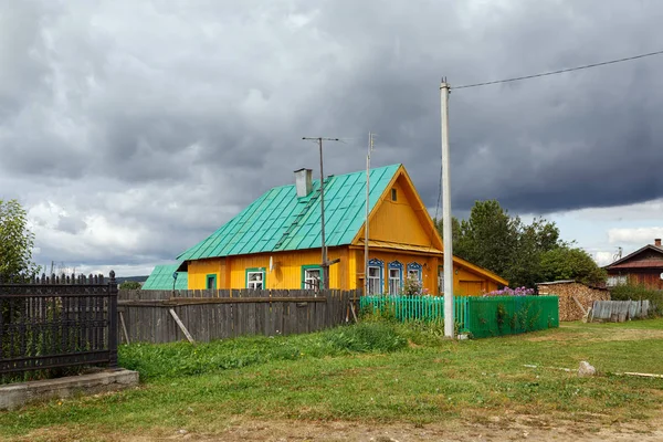 Russian village in summer. Brighty painted wooden residential house. Village of Visim, Sverdlovsk region, Russia.