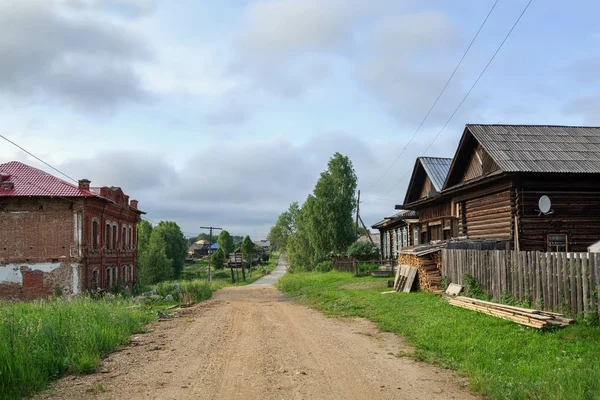 Неасфальтированная улица со старыми боковыми домами. Деревня Ом, Россия — стоковое фото