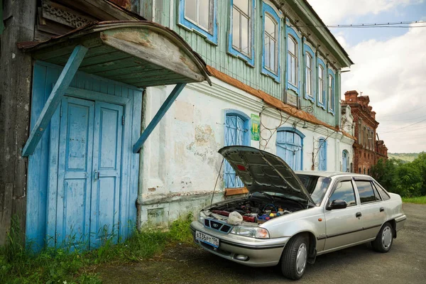 Carro moderno estacionado em frente ao edifício histórico. Vila de Visim, região de Sverdlovsk, Rússia — Fotografia de Stock