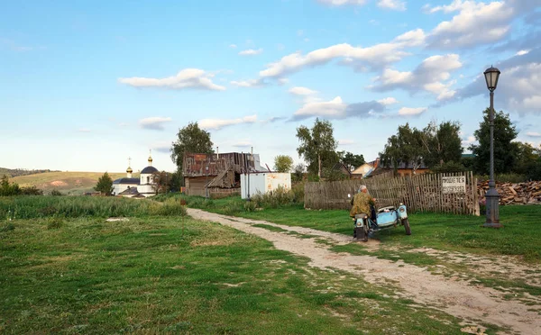 Yazın köy sokağı. Motosiklete binen adam Ural. Sviyazhsk, Tataristan Cumhuriyeti, Rusya Federasyonu.