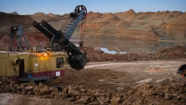 Caducidad del mineral de carga de la excavadora en camiones volquete al atardecer . — Vídeo de stock