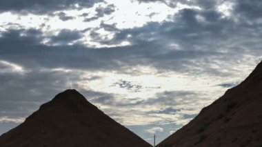 Güzel yığın bulutların üstünde çubuktaki Mısır piramitleri şeklinde kumlu tepeler üzerine mavi gökyüzü.