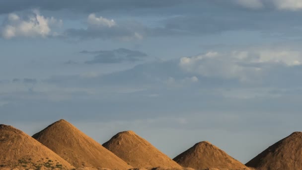 Nuvens heap bonitas no céu azul que se move sobre colinas arenosas na forma de pirâmides egípcias . — Vídeo de Stock