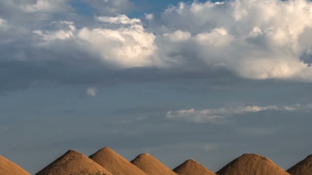 Schöne Haufenwolken am blauen Himmel, die sich über sandige Hügel in Form ägyptischer Pyramiden bewegen. — Stockvideo