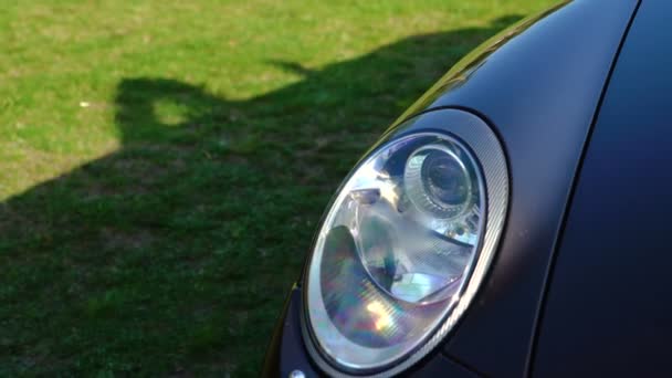 Headlight of Luxury brown Car Cabriolet in the bright summer forest glade. — Stock Video