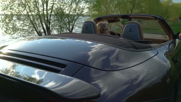 Joven mujer rubia bonita hablando en su teléfono en su nuevo coche con el interior moderno y asientos de cuero . — Vídeos de Stock