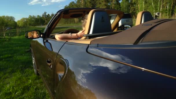 Joven mujer rubia bonita hablando en su teléfono en su nuevo coche con el interior moderno y asientos de cuero . — Vídeos de Stock