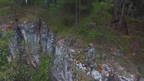 Bir telsiz bir dağ uçurumun kenarında üzerinde konuşurken korucu. — Stok video