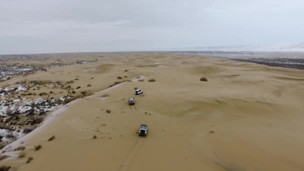 Veduta aerea dei SUV che attraversano il deserto innevato in inverno. Kazakistan occidentale, penisola di Mangyshlak . — Video Stock