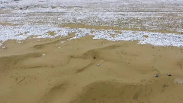 Luftaufnahme von Geländewagen, die sich im Winter durch die verschneite Wüste bewegen. Westkasachstan, Halbinsel Mangyshlak. — Stockvideo