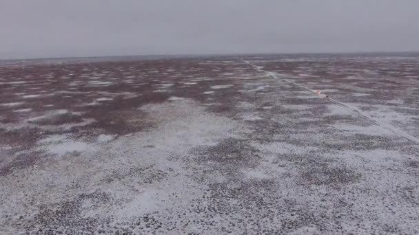 Aerial view of suvs moving through the snow-covered desert in winter. Western Kazakhstan, Mangyshlak Peninsula. — Stock Video