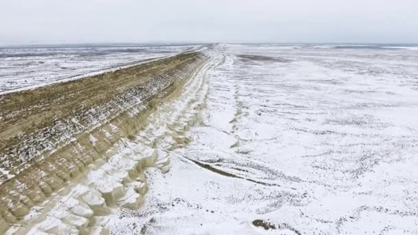 Bordo di una scogliera sabbiosa del deserto innevato in inverno. Kazakistan occidentale, penisola di Mangyshlak . — Video Stock