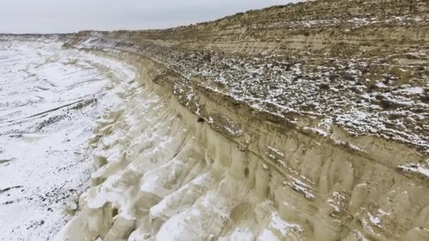 Borde de un acantilado arenoso del desierto cubierto de nieve en invierno. Kazajstán Occidental, Península de Mangyshlak . — Vídeo de stock