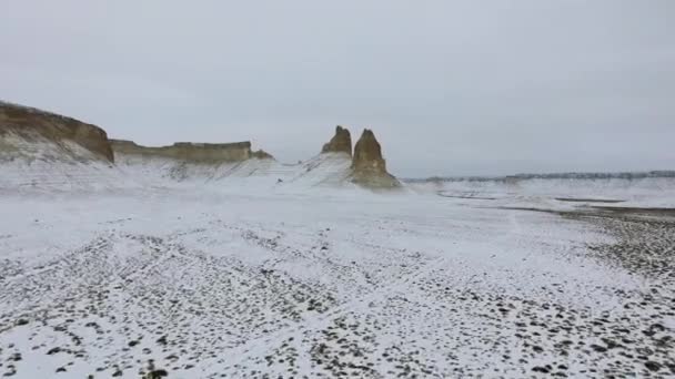 Erstaunliche Luftaufnahme der schneebedeckten Ustyurt sandigen Bergen in Westkasachstan, Halbinsel Mangyshlak. Wüste im Schnee. — Stockvideo