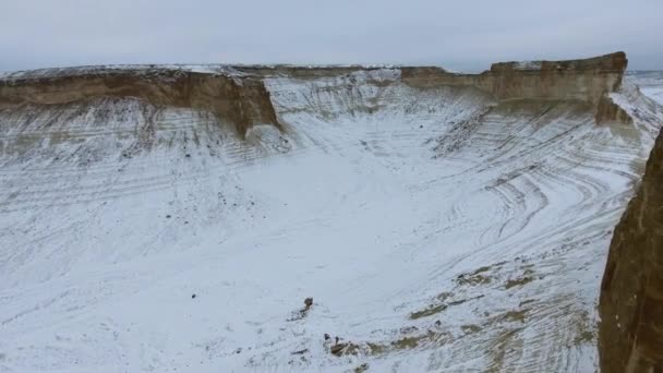 Increíble vista aérea de las montañas de arena Ustyurt cubiertas de nieve en el oeste de Kazajstán, península de Mangyshlak. Desierto en la nieve . — Vídeos de Stock