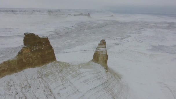 Erstaunliche Luftaufnahme der schneebedeckten Ustyurt sandigen Bergen in Westkasachstan, Halbinsel Mangyshlak. Wüste im Schnee. — Stockvideo