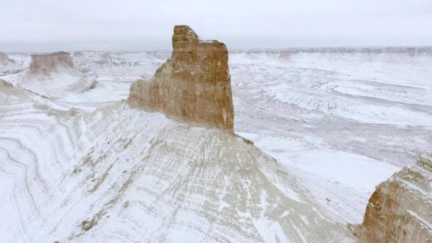 Vista aérea incrível de montanhas de areia de Ustyurt cobertas de neve no Cazaquistão Ocidental, Península de Mangyshlak. Deserto na neve . — Vídeo de Stock