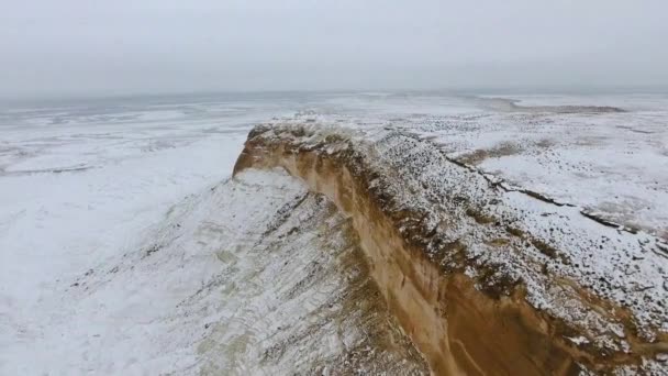 Удивительный вид с воздуха на заснеженные песчаные горы Устюрта в Западном Казахстане, полуостров Мангышлак. Пустыня в снегу . — стоковое видео