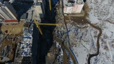 Trafik önünde yeni bir yerleşim alanı inşaatı karla kaplı.