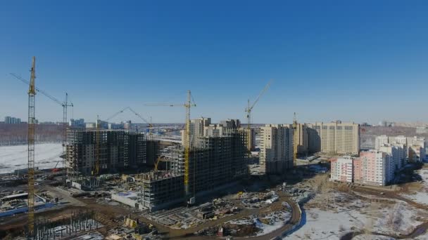 Construcción de una nueva zona residencial frente al tráfico rodado cubierto de nieve . — Vídeos de Stock
