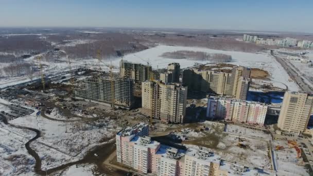 Pembangunan area pemukiman baru di depan lalu lintas jalan yang diselimuti salju . — Stok Video