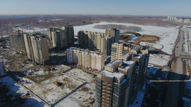 Строительство нового жилого района перед дорожным движением, покрытым снегом . — стоковое видео