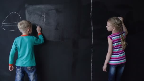 Bella ragazza bianca e ragazzo disegnare con un gesso su un muro nero. Timelapse . — Video Stock