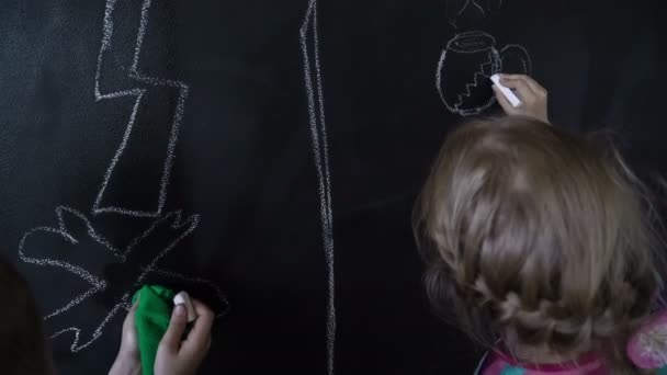 Beautiful white girl and boy draw with a chalk on a black wall. Timelapse. — Stock Video