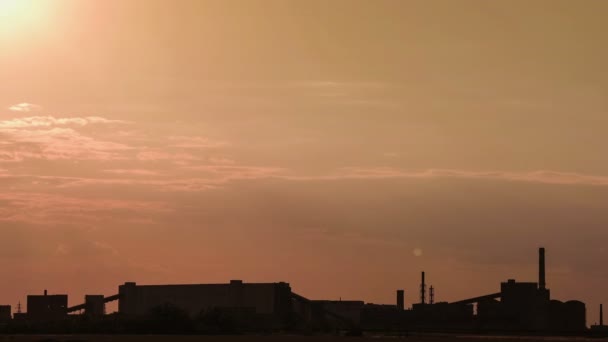 Siluet işleme tesisi, bir demir cevheri demir cevheri bir gün batımı arka planda açık döküm madencilik. — Stok video