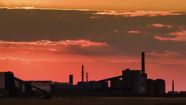 Silhuetten av en järn-malm bearbetningsanläggningen, dagbrott av järnmalm i bakgrunden av en solnedgång. — Stockvideo