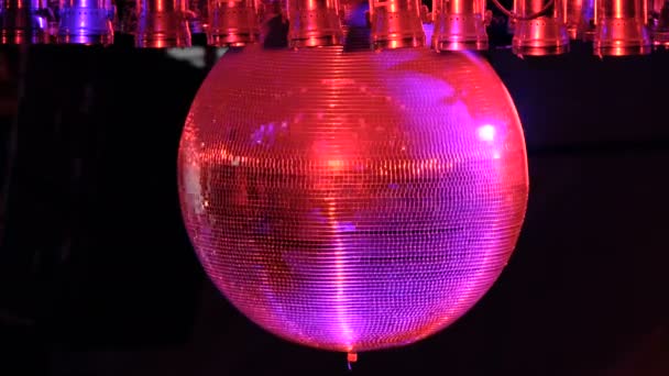 Disco ball with bright rays, night party background. disco ball hanging from the ceiling shines at the party. Disco ball — Stock Video